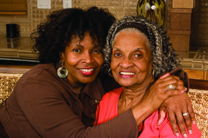 Caregiver woman smiling with elderly woman