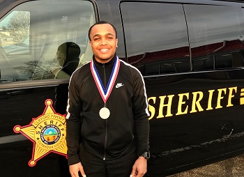 man standing in front of Sheriff van wearing a medal