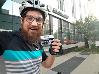 man holding a card wearing a bike helmet