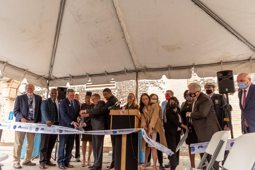 A group of County representatives and nonprofit leaders cut a ribbon