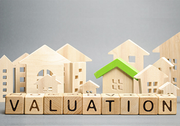 wooden houses with blocks that spell out valuation