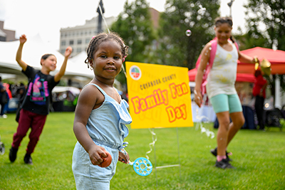 ChildrenrunningandplayingongrassnexttosignthatreadsFamilyFunDay