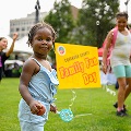 ChildrenrunningandplayingongrassnexttosignthatreadsFamilyFunDay