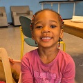Ayounggirlsmilingwithbraidsinherhair