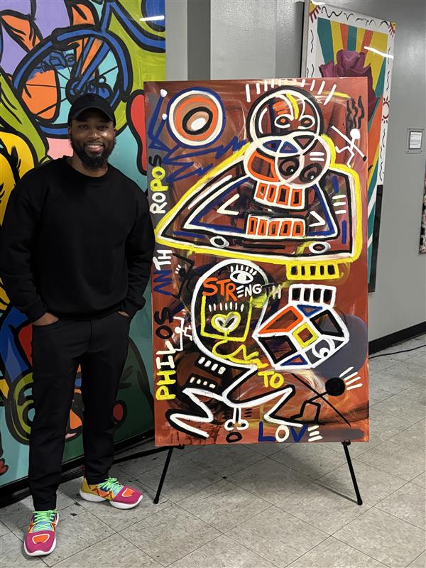 Halim A. Flowers standing next to his painting.