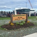 Awoodensignforanewtrailinalandscapedflowerbed