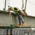 Amaninhi-resworkclothesworkingontheedgeofabridge