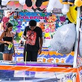 ASheriffinagolfcartistalkingtoapersoninamidwaybooth