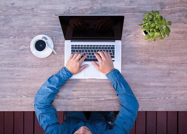 Man dressed nicely works at a laptop