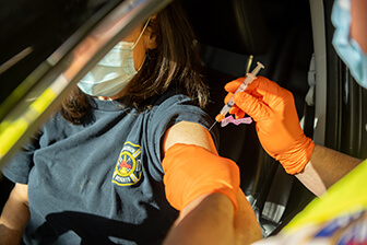 Woman in car receiving COVID-19 Vaccine