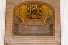 Stained glass arched window and marble staircase