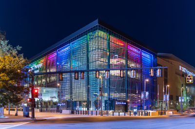 The glass of Rocket Mortgage Field House is lit up in a rainbow of colors.
