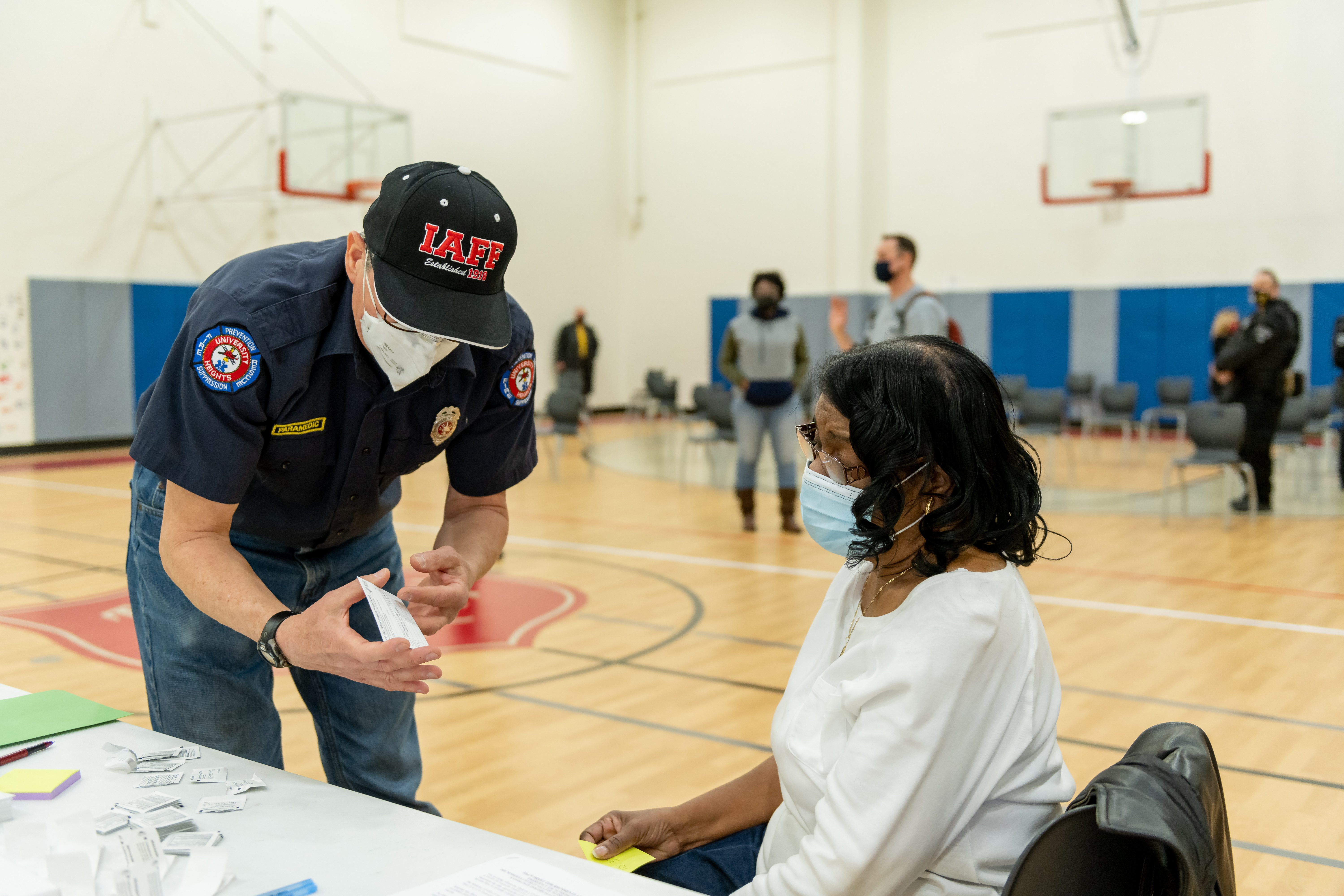 A healthcare professional prepares to give a woman her vaccine.