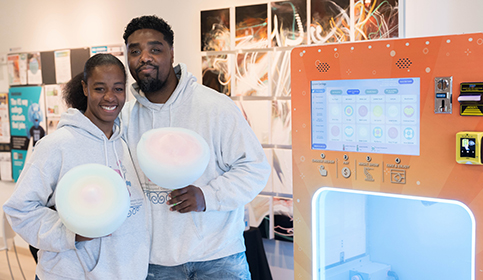 Small Business Man and Woman holding cotton candy next to cotton candy machine