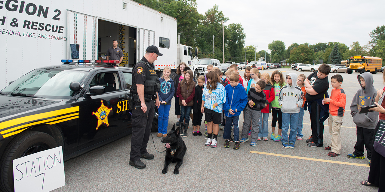 A Sheriff’s deputy and K-9 meet with a group of children.