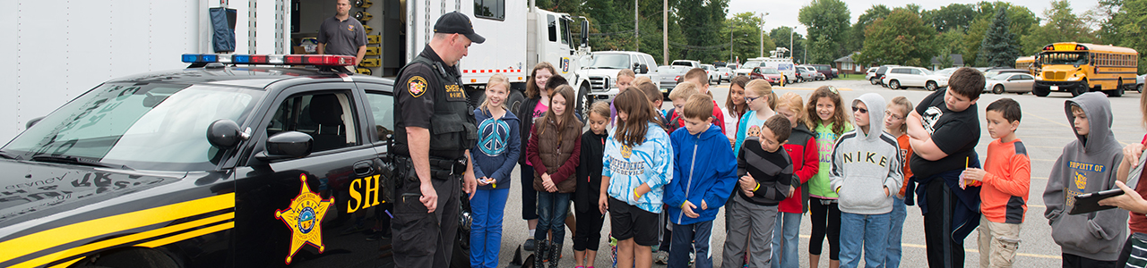 Sheriff’s Deputy with K-9 speaking to a group of children in front of his vehicle