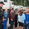 SheriffsDeputywithK-9speakingtoagroupofchildreninfrontofhisvehicle