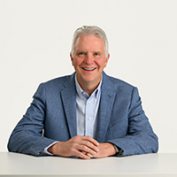 County Executive Chris Ronayne sitting at a desk and smiling