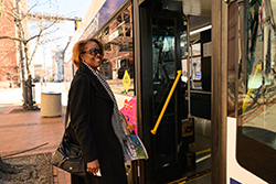 woman smiling and getting on a bus