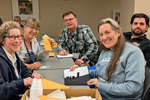 group of people smiling at a table holding documents