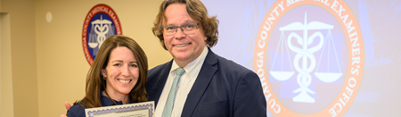 Woman holding certificate standing next to man