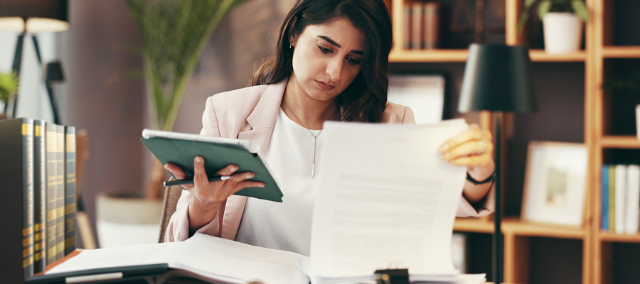 A paralegal sitting at her desk, going over legal documents.