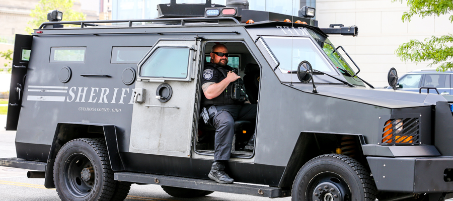 Sheriff-police One man in uniform, sitting in a sheriff's emergency vehicle at a public event.