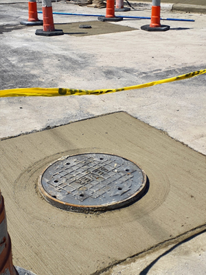 Closeup of sewer on street with construction