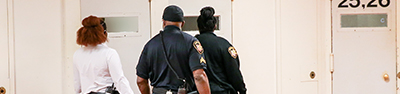 the backs of three officers walking down the hall of the Corrections Center