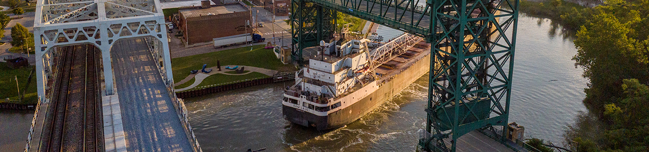 A boat passing under a bridge on the Cuyahoga River.