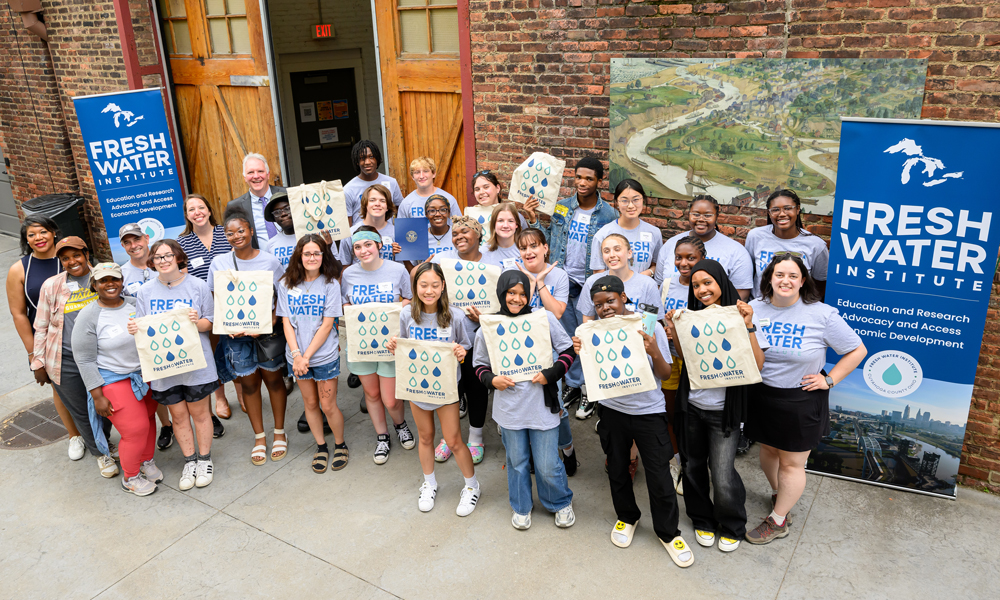 A large group of students and teachers posing in front of the Fresh Water Institute.