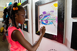 child painting on a wall with a black frame around the painting
