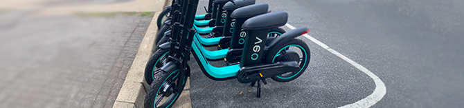 veo-feature E-scooters lined up in a designated parking zone.