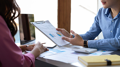 Male financial advisor explains data report and giving an investment recommendations to female client