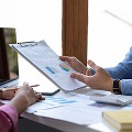 Malefinancialadvisorexplainsdatareportandgivinganinvestmentrecommendationstofemaleclient