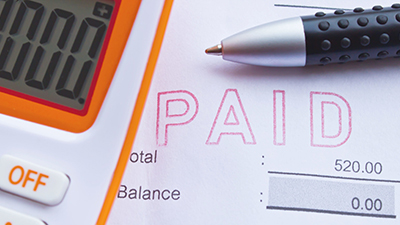 calculator and pen on top of a bill payment